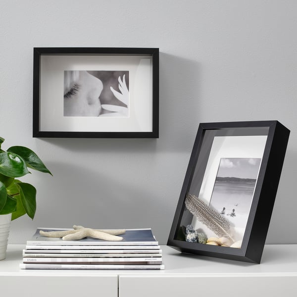 Black frames: eye & seascape. With books, plants. Alternative: black photo frames: eye & boats. With books, plants.