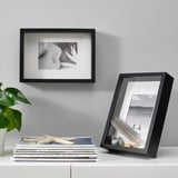 Black frames: eye & seascape. With books, plants. Alternative: black photo frames: eye & boats. With books, plants.