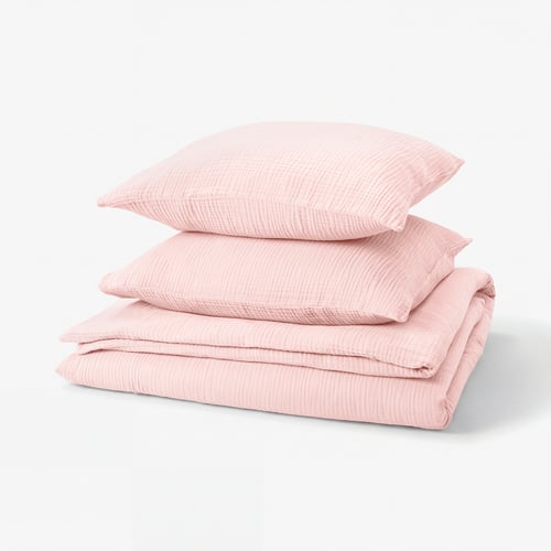 Displays a pink SCHERSMIN bedding set, featuring a duvet cover and two pillowcases in soft organic cotton with a textured, wavy design.