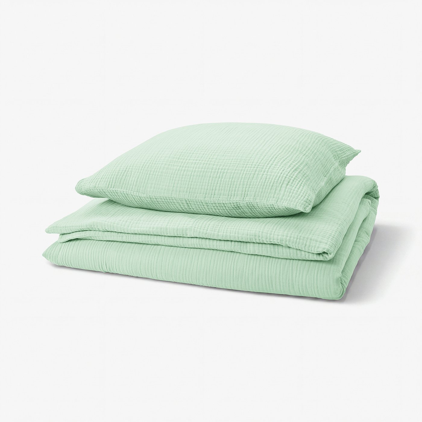 A green SCHERSMIN bedding set featuring a duvet cover and pillowcases made from 100% organic cotton with a wavy muslin texture.