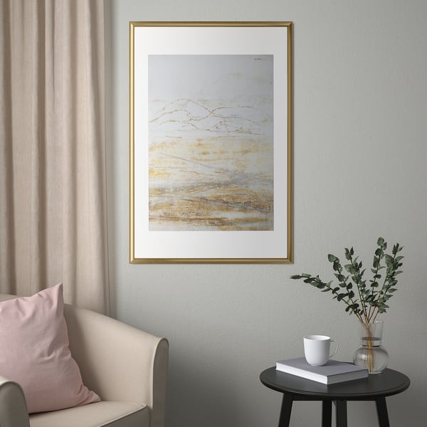 Modern living room decor: SILVERHÖJDEN frames, grey curtain chair, side table with book, mug, and eucalyptus.