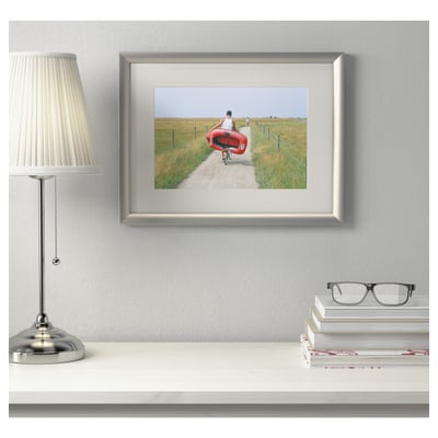 Framed photo on wall, next to lamp and books. Silver höjden frame can hang horizontally or vertically, with acid-free mount.