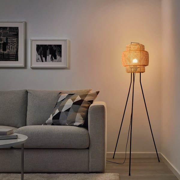 A cozy living room with SINNERLIG floor lamp, warm glow, and woven bamboo design.