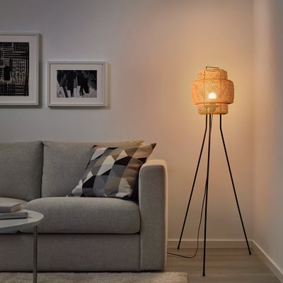 A cozy living room with SINNERLIG floor lamp, warm glow, and woven bamboo design.