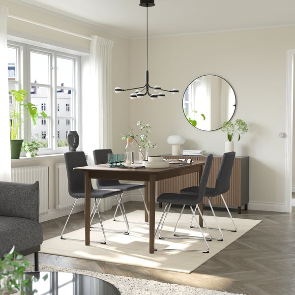 Modern dining area with SKANSNÄS table, chairs, green glassware, and mirror.