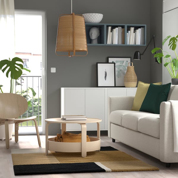 Modern living room with bold rug, sofa, and coffee table.