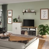 Modern living room with green walls, SKRUVBY tv stand, sofa, coffee table, and large window with curtains.