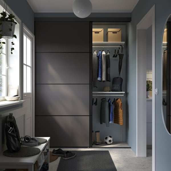 Modern entryway with blue-gray walls, SKYTTA closet open, mirror.