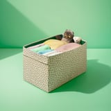 Leopard-print storage box with stuffed animals and folded clothes, designed for easy access and organization.