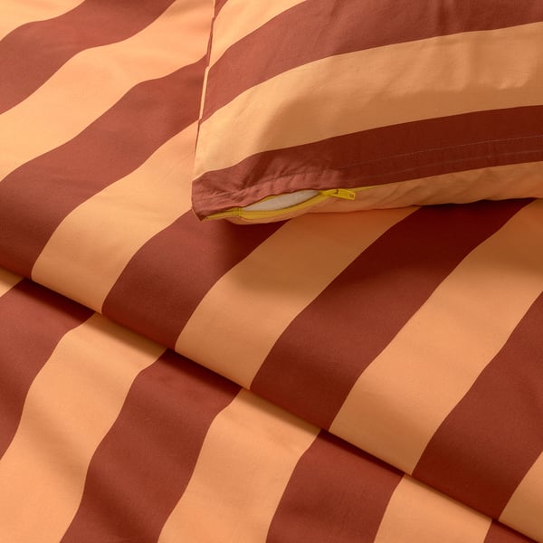 Close-up of striped bedding with detailed stitching and soft, woven fabric.