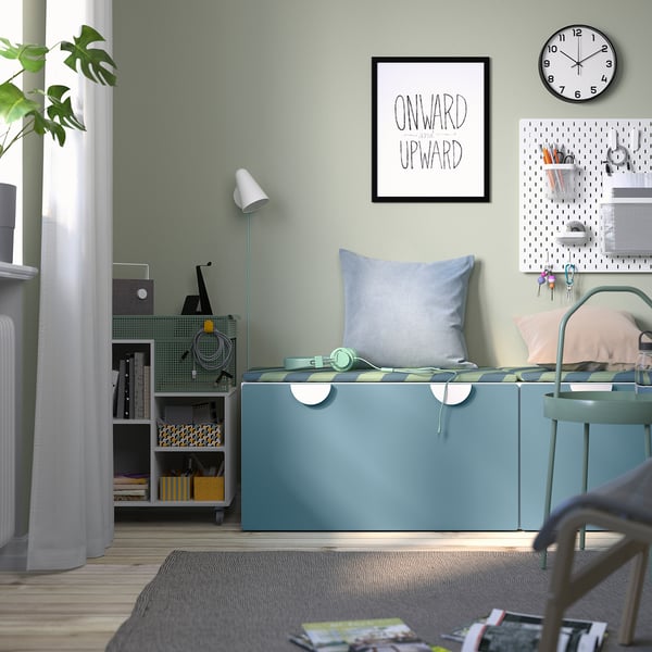 Home office: green bench, pillows, headphones, storage, art.