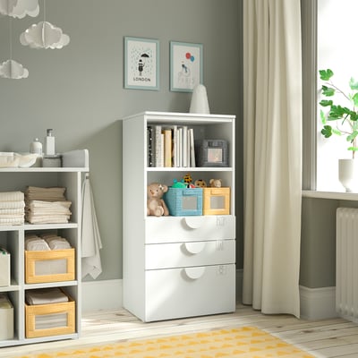 White SMÅSTAD storage unit with shelves and drawers in nursery. Decorated with toys and books.