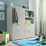 Modern kids room with white SMÅSTAD storage unit, blue rug, toy dinosaurs, and colorful decor.