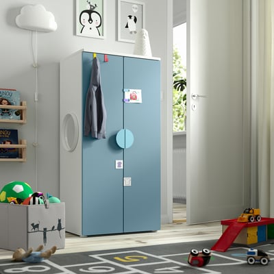 Blue SMÅSTAD kids wardrobe, light wood, adjustable. Walls decorated with prints, toys, and a playmat.