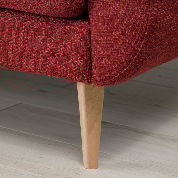 Red upholstered sofa with tapered wooden leg, showcasing modern comfort and retro style.