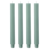 Four green fluted candles in a row.