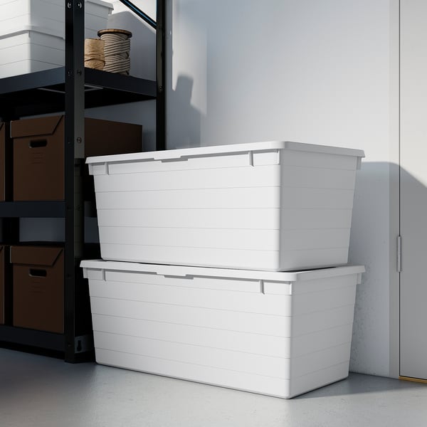 Two large white storage boxes, stacked neatly in a corner. Ideal for organizing and protecting bulkier items.