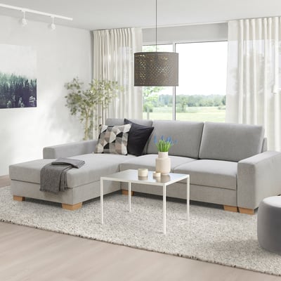 Modern grey l-shaped SÖRVALLEN sofa with cushions and white coffee table. Bright, minimalist living room.
