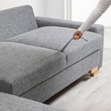 Person opens sofas storage under seat. Simple, modern sofa with extra space for items.