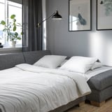 Transforming sofa bed with clean lines and white cushions, ideal for modern interiors.