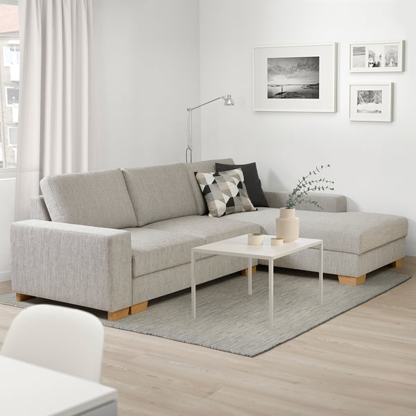 Gray SÖRVALLEN sectional sofa with chaise, patterned cushions, coffee table, black & white art.