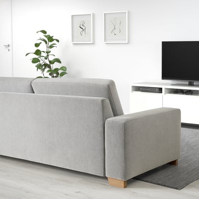 Grey SÖRVALLEN sofa with clean lines against white wall. 3-seat with wooden legs and box cushions.