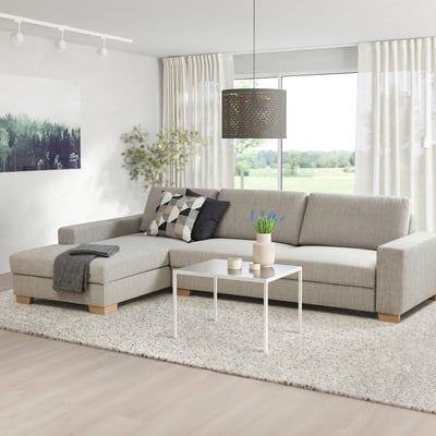 Grey l-shaped SÖRVALLEN sofa with minimalist design, cushions, throw, coffee table, and rug.
