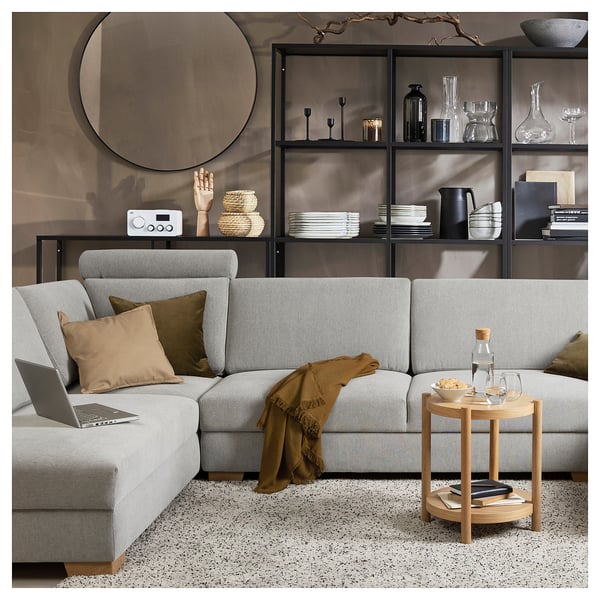 Modern living room with light gray SÖRVALLEN sofa, wooden side table, and black shelving unit filled with decor items.