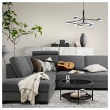 Modern living room with gray SÖRVALLEN sofa, coffee table, plant, and chandelier.