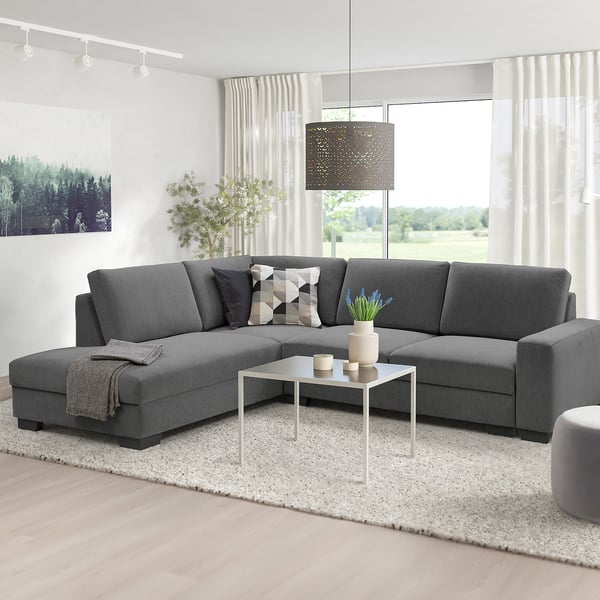 Grey sectional sofa with plush cushions in cozy living room.
