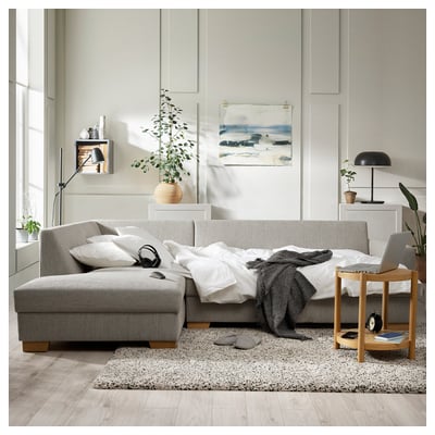 Gray sofa, white rug, side table, lamp, plants, art, headphones, cozy home.
