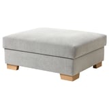 A gray SÖRVALLEN footstool with wooden legs and storage.