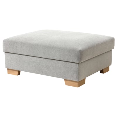 A gray SÖRVALLEN footstool with wooden legs and storage.