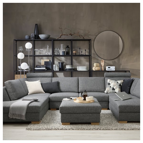Modern living room with gray SÖRVALLEN sectional sofa, cotton blend upholstery, surrounded by decorative shelves with items.