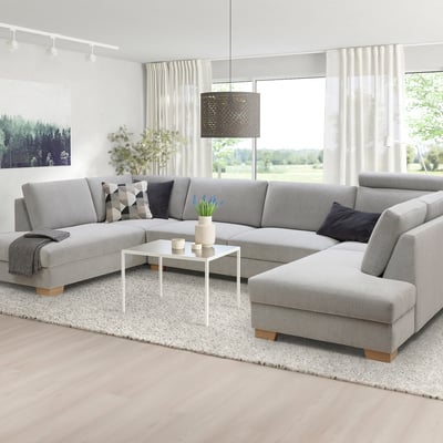 Modern gray l-shaped sofa set, minimalist design, large size, with cushions, coffee table, rug, and plants.
