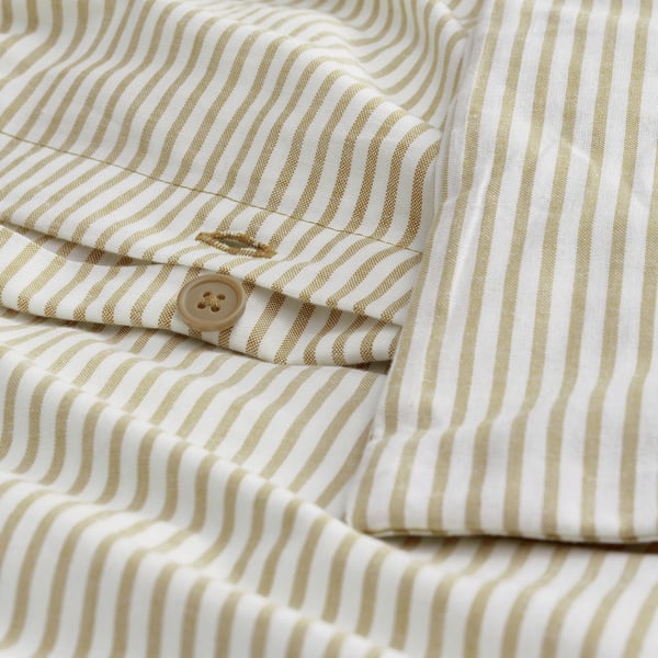Close-up of a mustard colored shirt with white stripes. Visible button and stitching, showing fabric texture and fit.