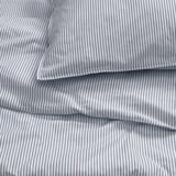 Crisp, blue-striped bedding set with neat folds, made from recycled cotton