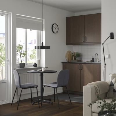 Modern kitchen with dark table, gray chairs, wooden cabinets, city view.