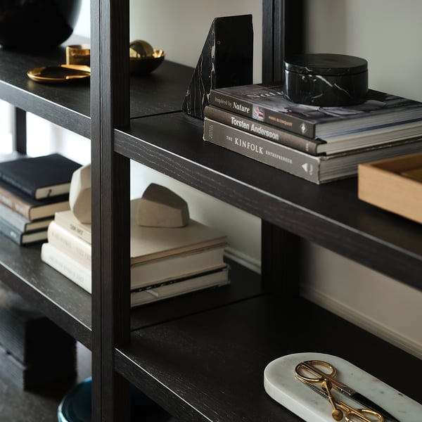 Bookshelf with multiple shelves displaying books and decorative items. Black marbled bookends hold books upright.