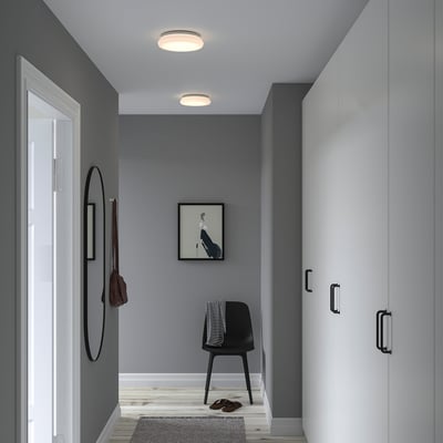 Hallway with gray walls, white cabinet, STOFTMOLN lamp, mirror, chair with blanket, picture.