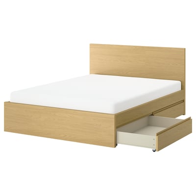 A storlinta bed in light oak with wooden headboard and rolling under-bed storage.