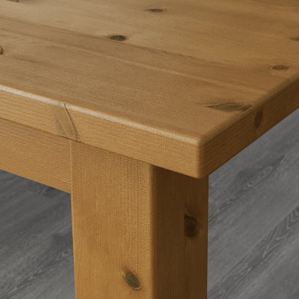 Robust, polished wooden table corner, displaying natural grain and durable finish.