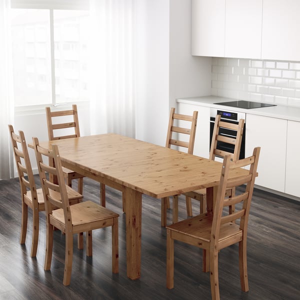 Wooden STORNÄS dining set in modern kitchen with white cabinets.