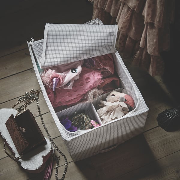 Open white STUK storage box with pink clothes and accessories.
