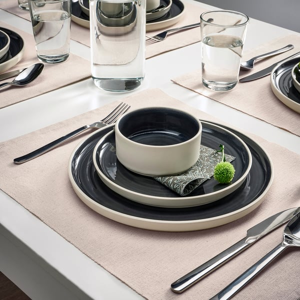 SVARTSENAP place mat with plates, bowl, cutlery, glass, napkin, and plant.