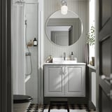 Modern gray bathroom with TÄNNFORSEN vanity, round mirror, and checkered floor.