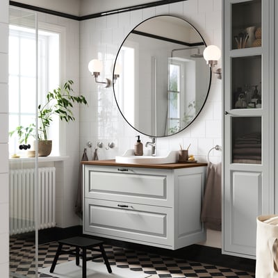 Modern bathroom: TÄNNFORSEN cabinet in light grey. Mirror, sink, plants.