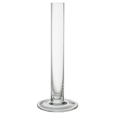 A TAJT glass vase. Its clear, tall, slender, with a wide base for stability. Perfect for long-stemmed flowers.
