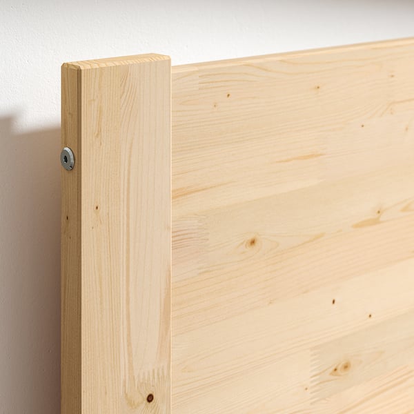 Close-up of sturdy, unfinished wooden bed frame corner, showcasing natural grain and smooth finish.