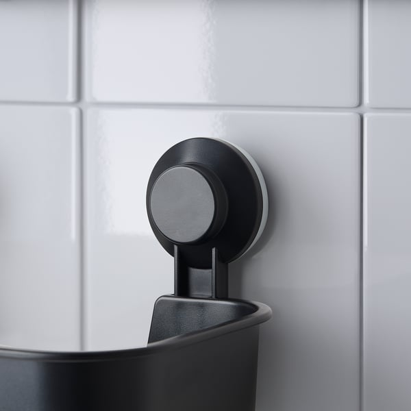Black TISKEN bathroom tier with round suction, holds shampoo securely.